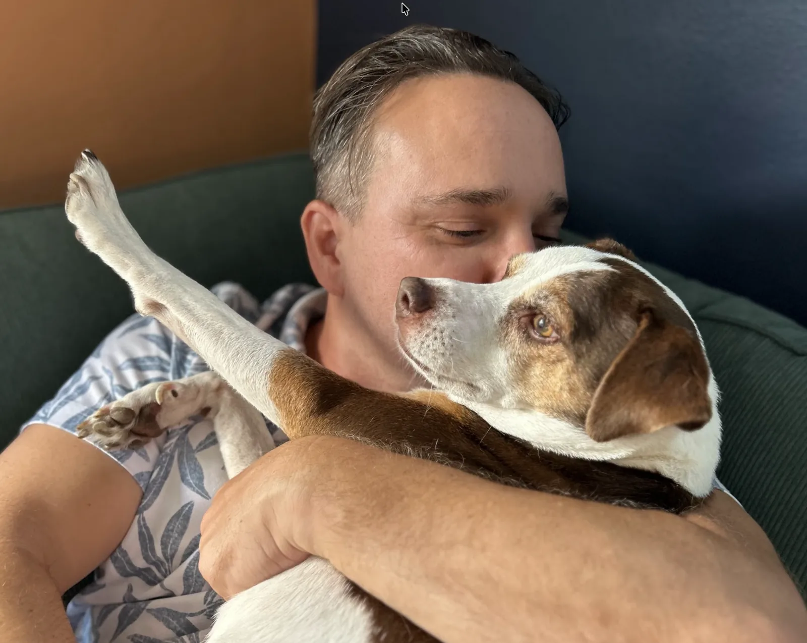 Eric holding Pickle cheek to cheek, Pickle's paw stretched up over his shoulder